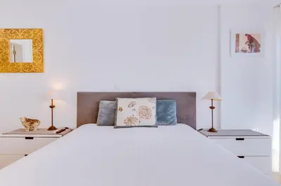 a white bedroom with a large white bed with two lamps at AL - Ocean Wide View in Quarteira