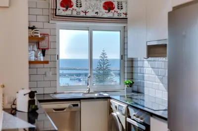a kitchen with a window with a view of the ocean at AL - Ocean Wide View in Quarteira