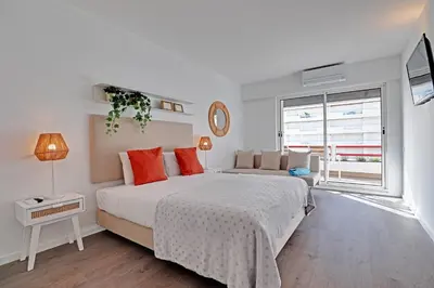 a white bedroom with a large bed with orange pillows at Home Out Vilamoura 20 Levante in Vilamoura
