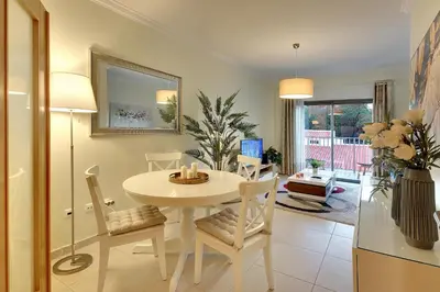 a dining room with a white table and chairs at RoofTop OldTown Residence in Albufeira
