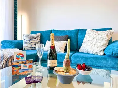 a living room with a blue couch and a bottle of wine at AlbufeiraOrada Gem by Be Cherish in Albufeira