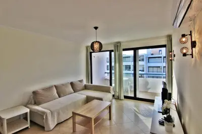 a living room with a couch and a table at Pé do Lago Apartment - Condominium - Pool in Quarteira