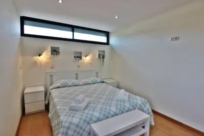 a small bedroom with a bed and a window at Pé do Lago Apartment - Condominium - Pool in Quarteira