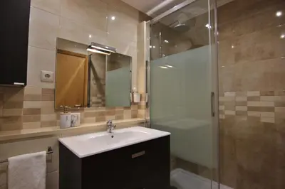 a bathroom with a sink and a shower at Pé do Lago Apartment - Condominium - Pool in Quarteira