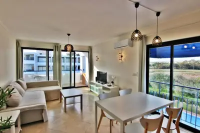 a living room with a couch and a table at Pé do Lago Apartment - Condominium - Pool in Quarteira