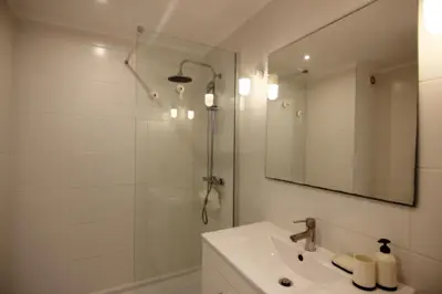 a bathroom with a shower and a sink and a mirror at Lago Azul Apartment I in Quarteira
