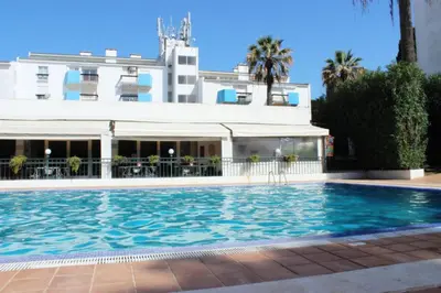 a swimming pool in front of a building at Lago Azul Apartment I in Quarteira
