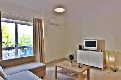 a living room with a couch and a tv at Lago Azul Apartment I in Quarteira