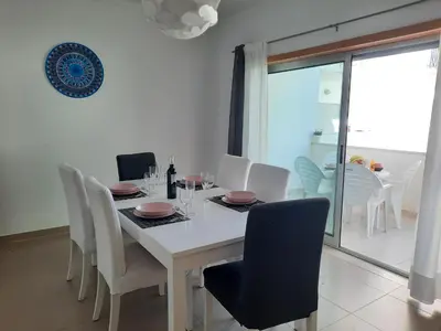 a white dining room with a white table and chairs at Casa Mandala, T1 com piscina in Albufeira