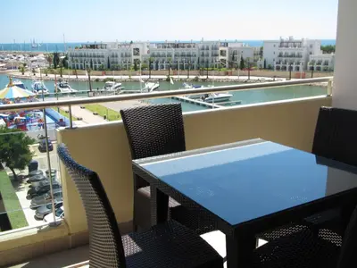 a table and chairs on a balcony with a view of a harbor at VilamouraSun Aquamar 406 - Vista Marina in Quarteira