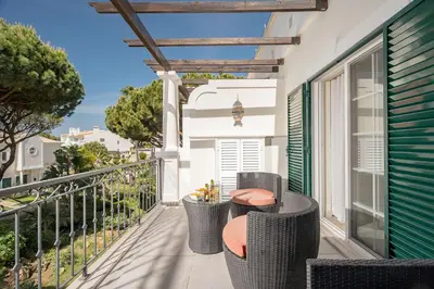 a balcony with wicker chairs and a table at Casa Ch'i - Vale de Lobo in Almancil