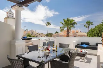 a patio with a table and chairs on a balcony at Casa Ch'i - Vale de Lobo in Almancil
