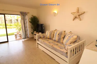 a living room with a couch and a starfish on the wall at Ocean Dream 84 - Apt. T1 na Praia de São Rafael, Albufeira in Albufeira