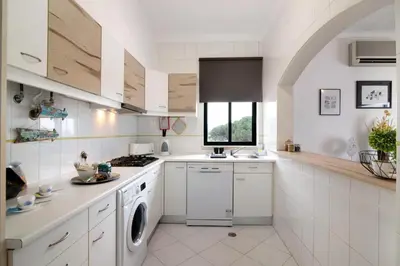 a kitchen with white cabinets and a stove top oven at Apartamento Medusa by Sunnyway in Olhos de Água