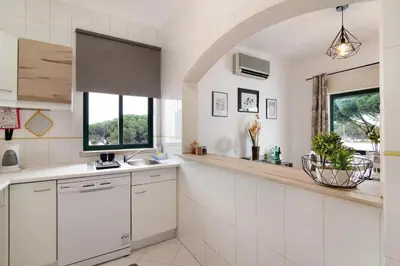 a kitchen with white cabinets and a window at Apartamento Medusa by Sunnyway in Olhos de Água