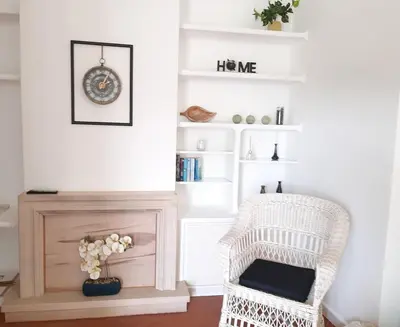 a living room with a chair and a fireplace at Apartamento Medusa by Sunnyway in Olhos de Água