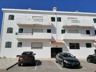 two cars parked in a parking lot in front of a building at Apartamento Medusa by Sunnyway in Olhos de Água