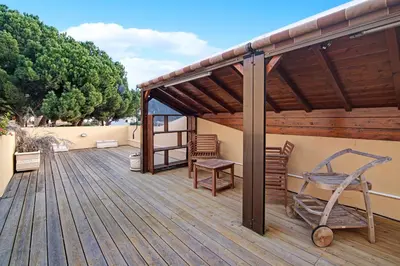 a wooden deck with a bench and a chair on it at Vilamoura Tenis 58 in Quarteira