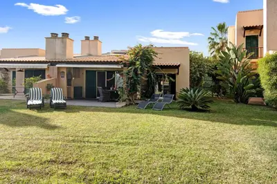 a house with two lawn chairs in the yard at Vilamoura Tenis 58 in Quarteira