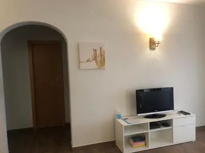a living room with a couch and a table and a clock at Apartamento Oceano in Albufeira