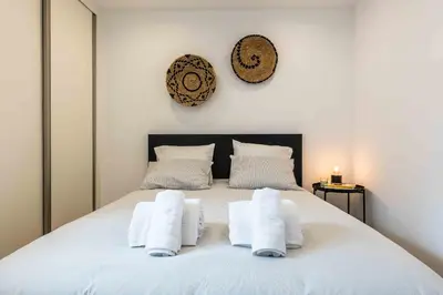 a bedroom with a white bed with towels on it at Santa Eulália 2-Bedroom Apartment - Swimming Pool - Wifi in Albufeira