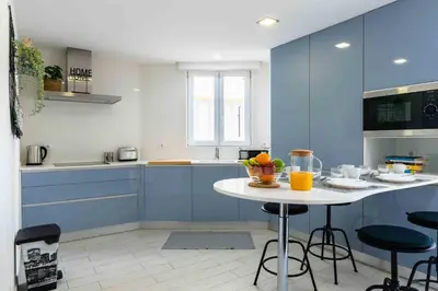 a kitchen with blue cabinets and a table with fruits on it at Santa Eulália 2-Bedroom Apartment - Swimming Pool - Wifi in Albufeira