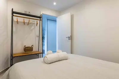 a bedroom with a white bed and a shower at Santa Eulália 2-Bedroom Apartment - Swimming Pool - Wifi in Albufeira