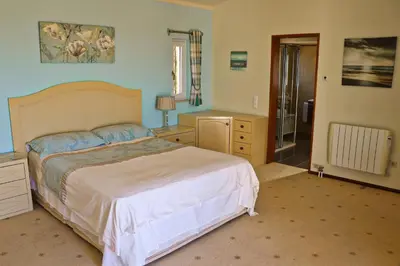 a bedroom with a bed and a bathroom with a shower at Villa Santa Barbara by Portucasa in Bordeira