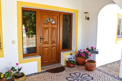 a front door of a house with potted plants at Villa Santa Barbara by Portucasa in Bordeira