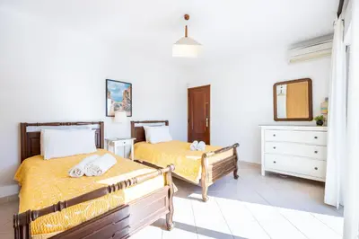 a bedroom with two beds and a mirror at Villa dos Netos in Albufeira