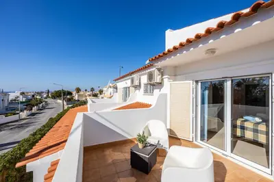 a white house with a view of a street at Villa dos Netos in Albufeira