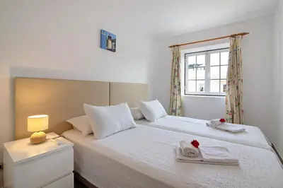 a bedroom with a bed with two towels on it at Apartamento Old Village T2 Duplex in Quarteira