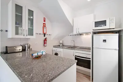 a kitchen with white cabinets and a counter top at Apartamento Old Village T2 Duplex in Quarteira