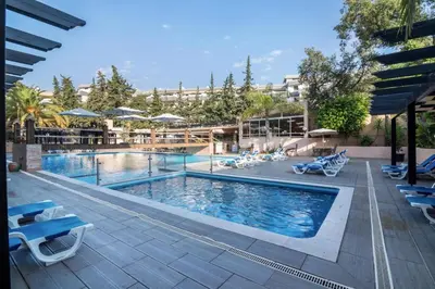 a swimming pool with blue chairs and a resort at Apartamento Malick by Sunnyway in Branqueira