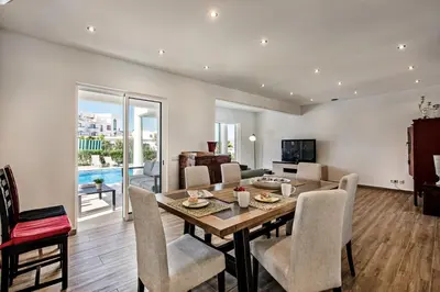 a dining room and living room with a table and chairs at Silva by Algarve Villa Holidays in Albufeira