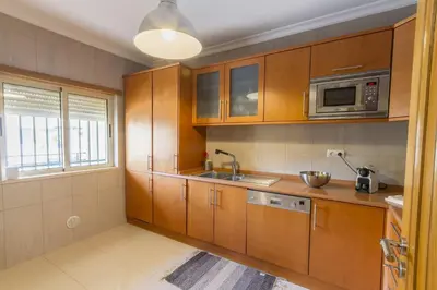 a kitchen with wooden cabinets and a microwave at Millennium Plaza in Vilamoura
