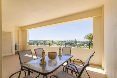 a dining room with a table and chairs and a large window at Millennium Plaza in Vilamoura