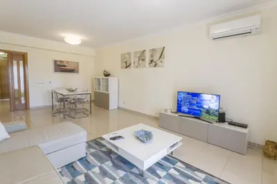 a living room with a couch and a tv at Millennium Plaza in Vilamoura