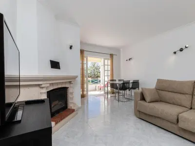 a living room with a couch and a fireplace at Akisol Albufeira Water in Albufeira