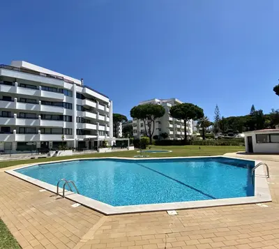 a large swimming pool in front of a building at Ténis Studio Apartment - Vilamoura in Vilamoura