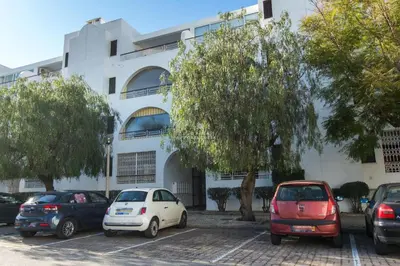 a group of cars parked in a parking lot in front of a building at Apartment Salgados Lounge - By Dalma Portuguesa in Albufeira
