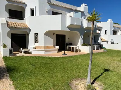 a white house with a palm tree in the yard at Casa Sophie Albufeira in Albufeira