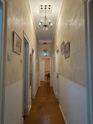 a hallway with a chandelier on the wall and a hallway with a hallway at Ti Maria Guest House in Faro