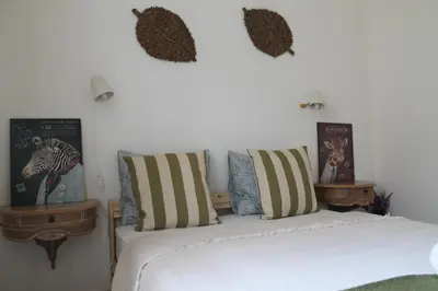 a bedroom with a bed with striped pillows on it at Ti Maria Guest House in Faro