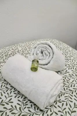 a couple of towels with a bottle on top of them at Ti Maria Guest House in Faro