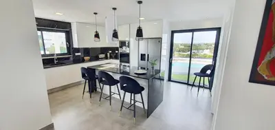 a kitchen with a table and chairs and a kitchen with a pool at Sky Villa by Laranjal Rentals in Albufeira