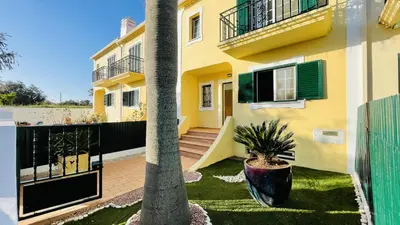 a house with a palm tree in front of it at Mosqueira by Check-in Portugal in Albufeira