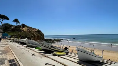 a row of boats are lined up on the beach at Mosqueira by Check-in Portugal in Albufeira