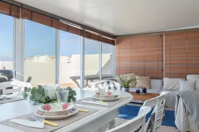 a living room with a table and chairs and a couch at Apartment Marina in Albufeira