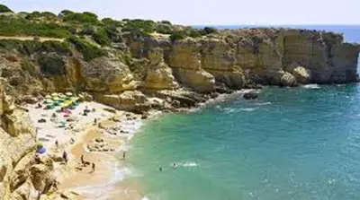 a group of people on a beach near the water at Villa Coelho in Albufeira